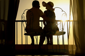 A Couple man and woman silhouette on a balcony by the sea on the background. Meeting in a double date on the terrace. - 799132388