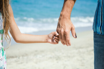 A Hands of a happy parent and child on the seashore on a journey trip in nature - 799133174