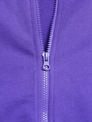 Closeup of half closed plastic zipper at purple cotton casual sweatshirt