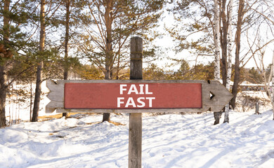 Fail fast symbol. Concept words Fail fast on beautiful wooden road sign. Beautiful forest snow blue sky background. Business and fail fast concept. Copy space.