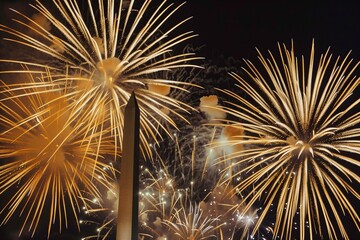 Golden fireworks explode in the sky above the Washington Monument during a vibrant night celebration