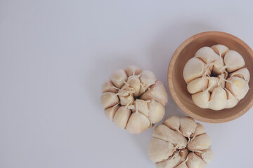 Garlic cloves and bulb in wooden bowl. Healthy food. Garlic with white isolated object.