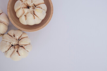 Garlic cloves and bulb in wooden bowl. Healthy food. Garlic with white isolated object.