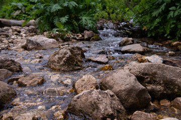 Beautiful mountain landscape in early spring. Small river with a waterfall.