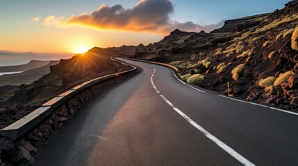 Curving coastal road through a volcanic landscape at sunset