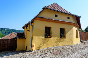 Old colorful painted house in the historical center of the Sighisoara citadel, in Transylvania (Transilvania) region of Romania, in a sunny summer day.