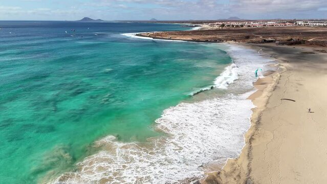 Overview of the beach and the beach line in Ponta Preta, Sal, Cape Verde, while waves are breaking and kiter walking to the spot
