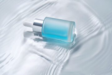 Bottles of cosmetics with a dropper in water on a blue background.