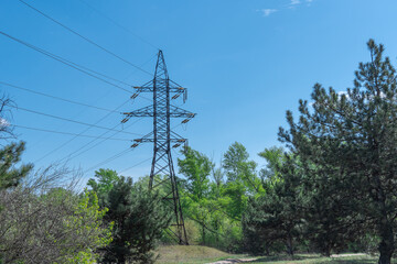 Electricity transmission towers and power lines in forest. High voltage pole on road. Energy...