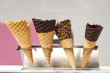A close up of a choice of ice cream cones, waiting to be filled with ice cream