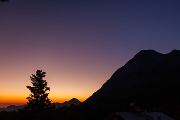 Obraz premium Bright colorful sunset sky over black silhouettes of mountains. Dark sunset sky with bright colors over the mountain. Turkey.