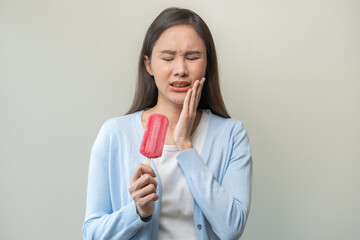 Face expression suffering from sensitive teeth and cold, asian young woman, girl hand touching cheek, hurt or pain eating ice cream. Toothache molar tooth, dental problem isolated on white background.