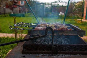 Cooking kebabs on a grill with smoke. Fresh brown BBQ meat cooked on an outdoor grill