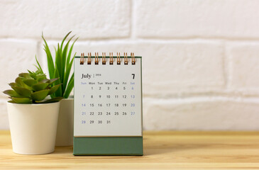 Desk calendar for July 2024 on the table with copy space.