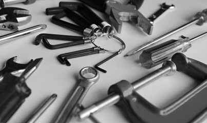 Grayscale Image Of Home Repair Tools On White Table Detailed View. Home Work And Repair Equipment...