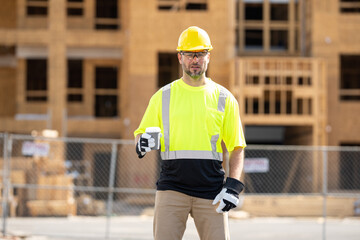 A construction worker at a construction site drinks coffee during a break. builder man in a helmet...