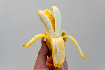Holding a peeled Banana in a non-traditional way, showing the internal parts of the fruit