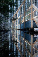 A reflection of a bridge on a flooded nature pathway.