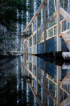 A reflection of a bridge on a flooded nature pathway.