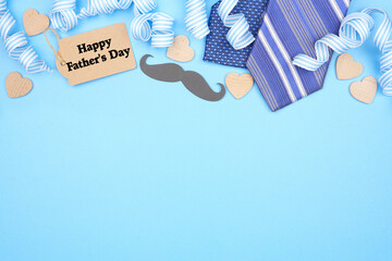 Happy Fathers Day gift tag with top border of gifts, decor, ties and ribbon. Overhead view on a...