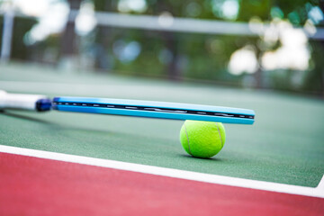 Tennis racket and ball on the court. Close-up.