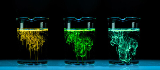 Dissolution and spread of a coloured chemicals in flask with a clear liquid.