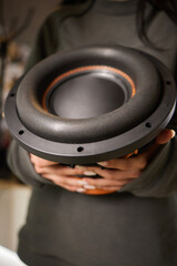 An automotive speaker is installed in a car door for audio equipment