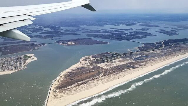 Beautiful view from the airplane window of the coastal landscape of the Atlantic Ocean during landing at New York airport.