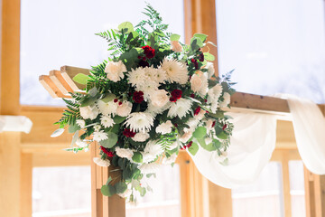 An arrangement of fresh flowers decorates a wedding arch