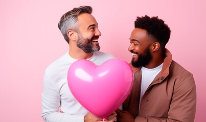 Gay couple holding heart-shaped balloon, LGBT, pride, two happy men, valentine's day, relationship between white man and black man, pink background.