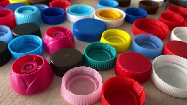 recyclable materials. bottle caps on the table. plastic particles. slow motion video. High-quality shooting in 4K