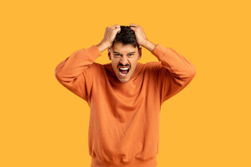 Man in Orange Shirt Holding Hair in Anger