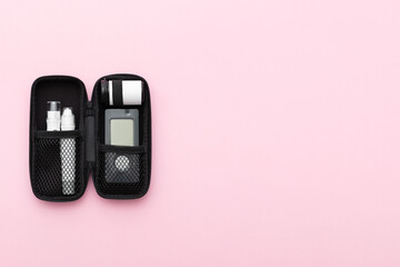 Glucometer on a pink background. Device for measuring blood sugar levels. Top view. Space for text.