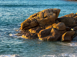 Coastal Serenity: Sunlit Rocks by the Sea