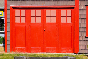 An image of an old vintage style garage door with bright red paint. 