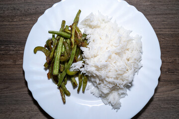 Vegetarian dinner with fried green beans, peppers and cooked rice