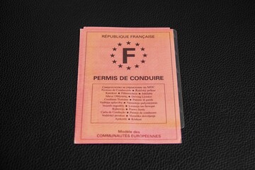 Un vieux permis de conduire Français en papier rose sur support noir 