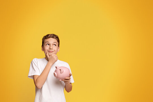 Teen boy with piggy bank dreaming about some things he can buy