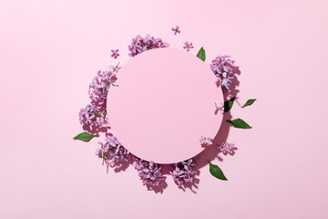Lilac on a pink background. Beautiful fresh flowers. Cosmetic circle podium and lilac on light pink...