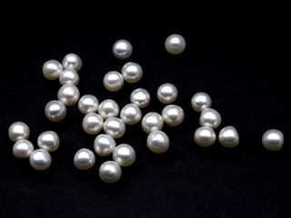 Expensive and luxurious round saltwater South Sea pearls on black background, ready to be made into beautiful earrings, pendants or necklaces and sold in a jewelry store. Popular wedding accessory.