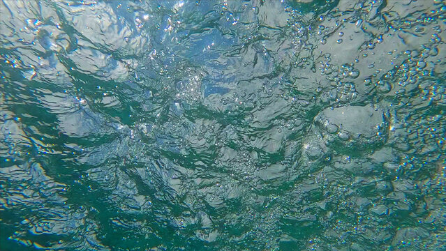 Underwater view on the churning water surface