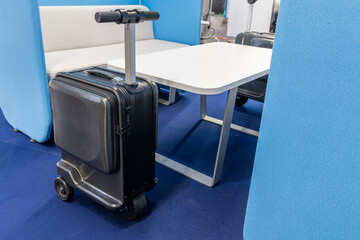 Electric scooter suitcase at the airport. The future of baggage.