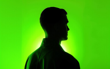 A man's silhouette against a neon green background, with soft lighting casting gentle shadows on his face and shoulders,Focusing on the upper body. Generative AI.