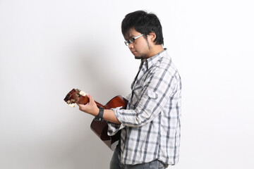 An Asian guitarist playing acoustic guitar on a white background