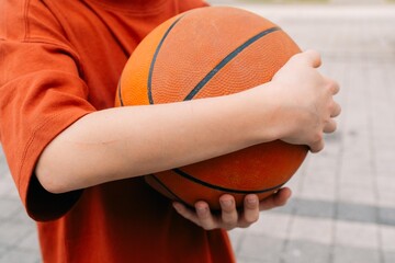 teenage boy wrapped his hands around the ball after playing basketball