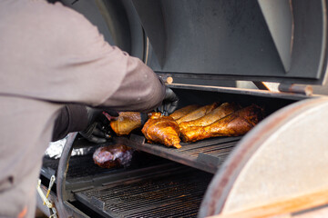 Turkey legs are baked on a professional grill. The process of preparing meat for a picnic