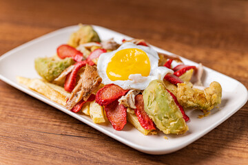 Salchipapa, French fries, hot dog, chicken, egg and crispy avocado.