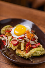 Salchipapa, French fries, hot dog, chicken, egg and crispy avocado.