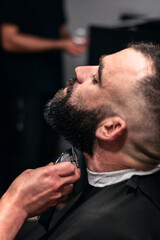 Close-up of a man having his beard trimmed.