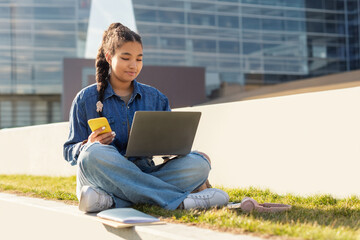 Girl Sitting With Laptop and Cell Phone